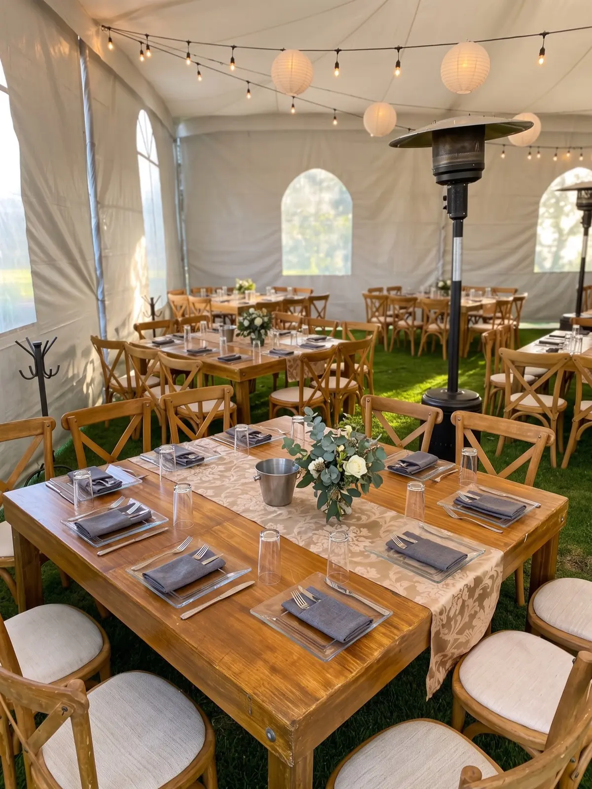 Carpa para boda con sillas de madera cruzadas y montaje en tonos neutros