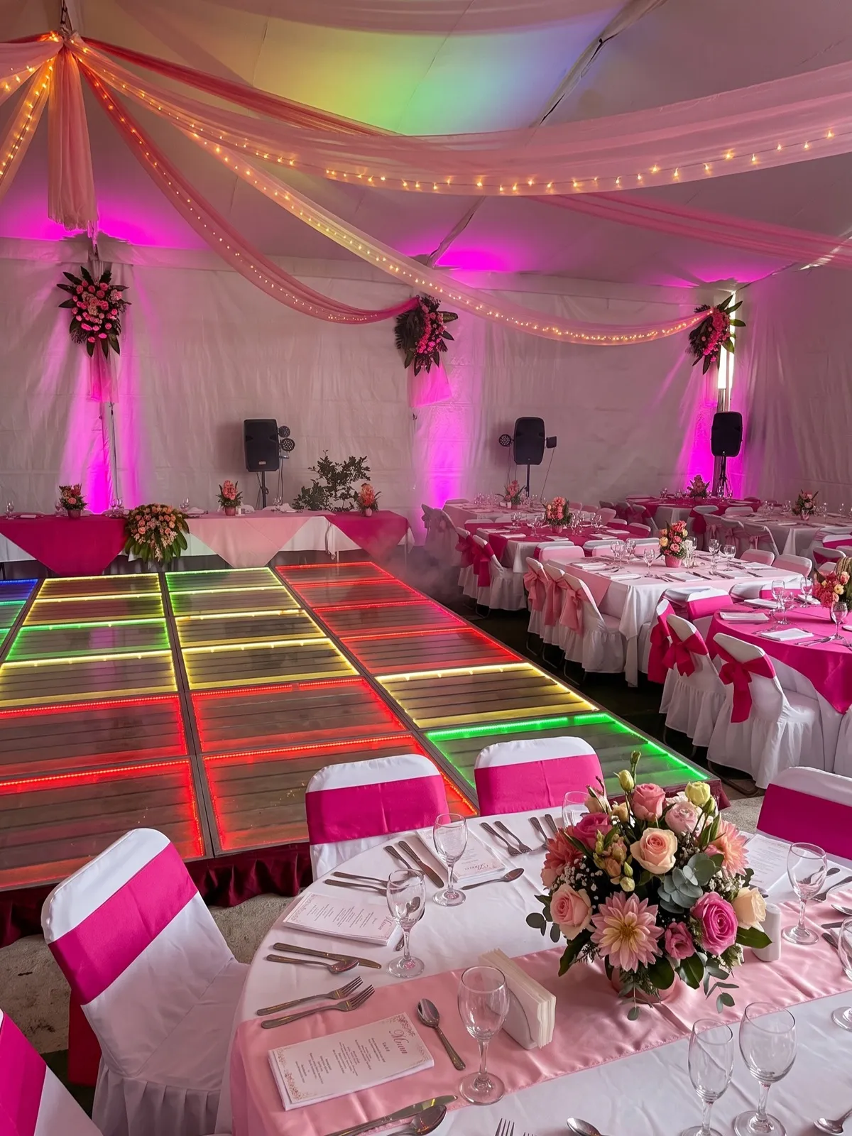 Carpa de XV años con pista de baile iluminada en rosa y verde